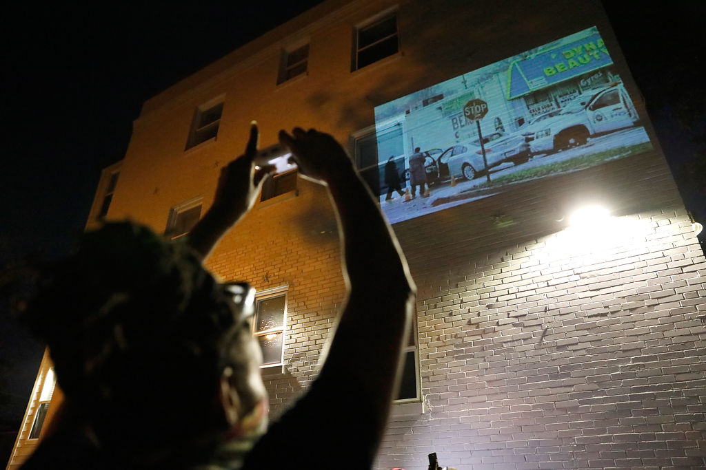 A woman uses a handheld projector